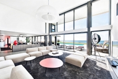 Intérieur design, grande piece de vie contemporaine ouverte sur l'océan. Salon et séjour moderne de blanc et de gris
